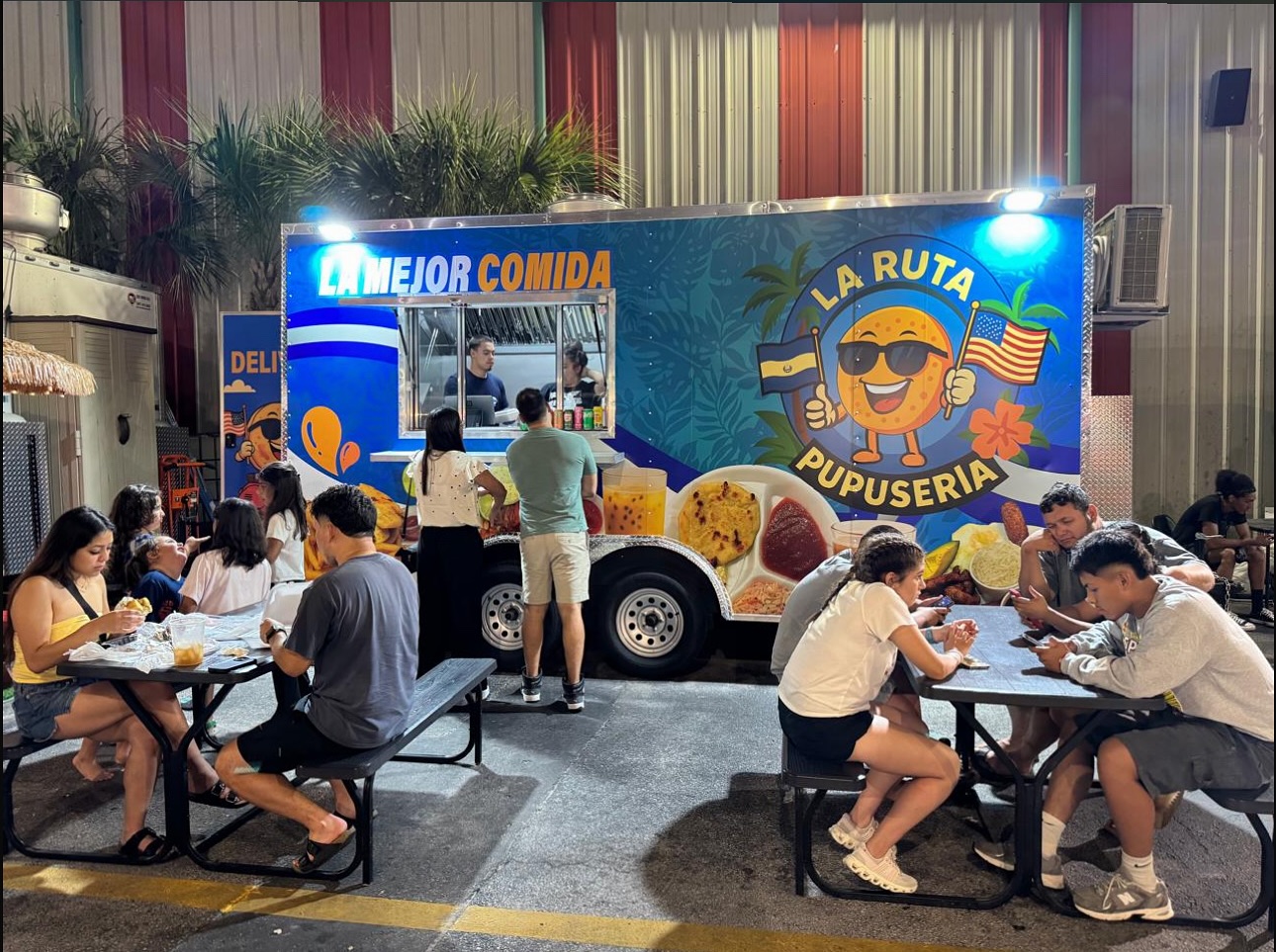 Visitors enjoying Latin street food at Food Trucks Heaven in Kissimmee, Florida, seated in the outdoor dining area.
